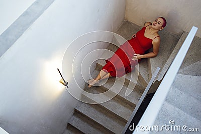 Beautiful relaxed woman in red long dress and red shot hair looking good Stock Photo