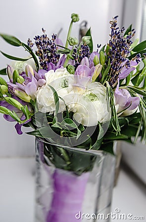 Beautiful rich bunch of purple fresia, buttercup ranunculus peony, green leaf, lilac lavender, roses, rosemary bouquet Stock Photo