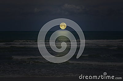 Beautiful rising full moon in blue sky over the sea Stock Photo