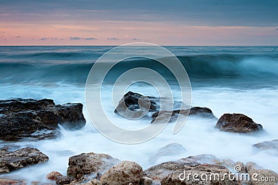 Beautiful rocky sea beach at the sunset Stock Photo