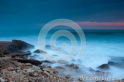 Beautiful rocky sea beach at the sunset Stock Photo