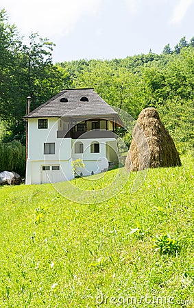 Romanian traditional villa with haystack and green grass - Oltenia province, Romania Stock Photo