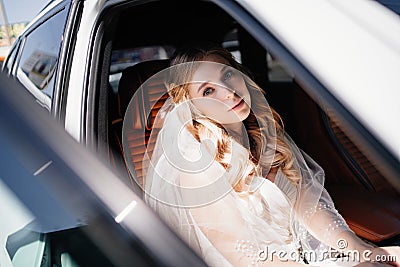 A beautiful and romantic bride sits in cars. Rent transport for the wedding. Stock Photo