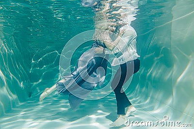 Beautiful romantic couple of lovers hugging gently under water Stock Photo