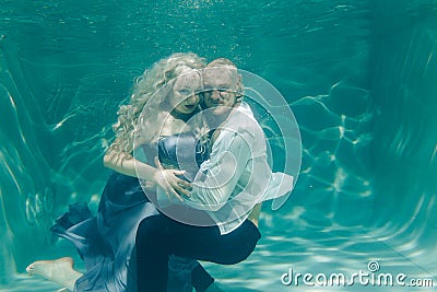 Beautiful romantic couple of lovers hugging gently under water Stock Photo