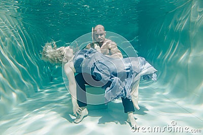 Beautiful romantic couple of lovers hugging gently under water Stock Photo