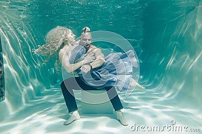 Beautiful romantic couple of lovers hugging gently under water Stock Photo