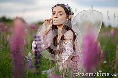 Beautiful romantic girl on nature field of flowers. Photo of sensual woman. Stock Photo