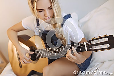 Girl Playing Guitar at Home Stock Photo