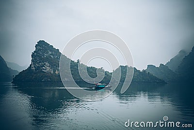 A fisherman in his boat in Ha Long Bay Vietnam Stock Photo