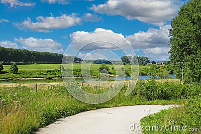 Beautiful rural dutch valley landscape, cycling path, river Maas, green forest, idyllic farm meadows - Maasvallei, Limburg, Stock Photo