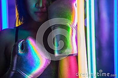 Beautiful 20s Asian Woman punch, poses with Silver gold Mitts Gloves. Office Girl exercise between Modern multi color Fashion Neon Stock Photo