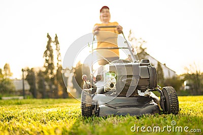 Portrait of beautiful 50s senor woman cutting grass with gasoline lawn mower, gardening Stock Photo