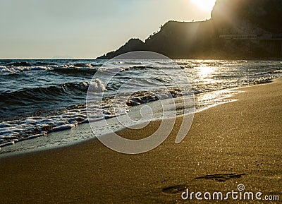 Beautiful sandy Mediterranean beach at sunset and footprints on the sand. Stock Photo