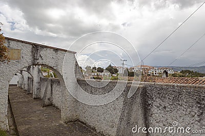 Beautiful scene of an old white arc alley peatonal street in middle of colonial Colombian town Editorial Stock Photo