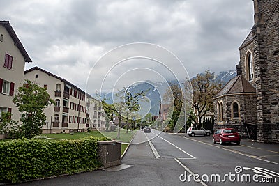 Beautiful scene of street with buildings in Interlaken on mountain and cloudy sky background Stock Photo