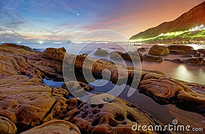 Beautiful scenery of dawning sky by rocky beach in northern Taiwan Stock Photo