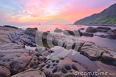 Beautiful scenery of dawning sky by rocky seashore in northern Taiwan (long exposure effect) Stock Photo