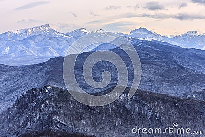 Beautiful scenic winter mountain landscape of Lagonaki mountain region with snowy peaks and forest valley. Bolshoy Tkhach mountain Stock Photo