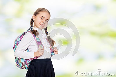 Beautiful schoolgirl with a backpack behind her shoulders. Stock Photo