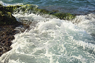 Beautiful sea wave background with green rock shore and foam near the seashore. Contrast color portrait Stock Photo