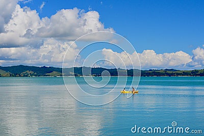 Seashores of New Zealand; beautiful seascape, bright blue ocean, and some people far away enjoying water activities. Editorial Stock Photo