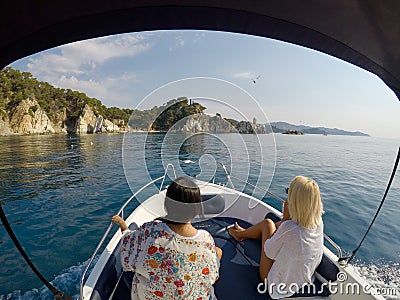 Beautiful seascape of two girls sailing a rental boat at the Mediterranean Sea in the Spain Costa Brava Editorial Stock Photo