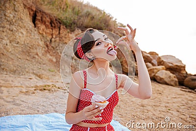 Beautiful seductive pin up girl eating cream cake Stock Photo