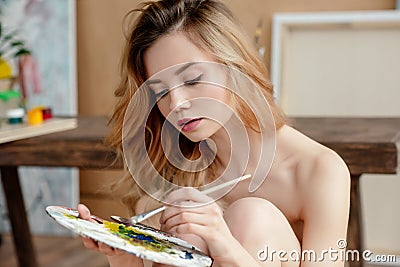 beautiful sensual naked young artist holding palette and brush Stock Photo