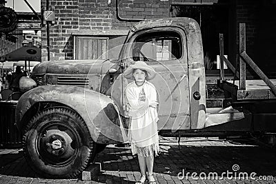 Beautiful serious little girl standing in front of old classic vintage retro truck Stock Photo