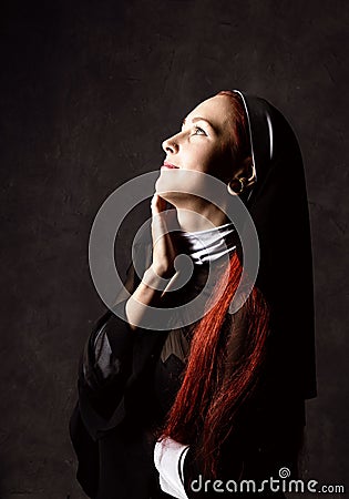 Beautiful catholic nun posing on a dark background. religious concept Stock Photo