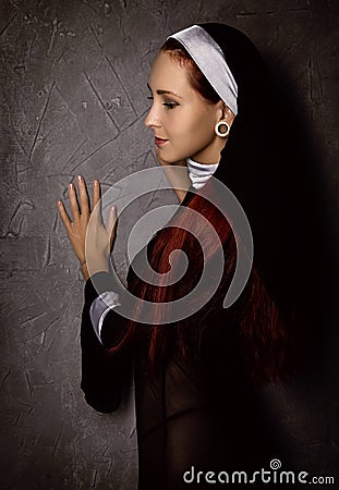 Beautiful catholic nun posing on a dark background. religious concept Stock Photo