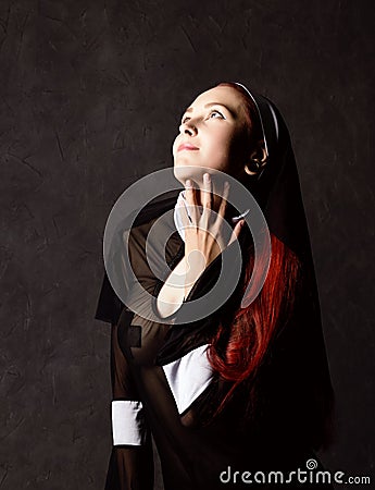 Beautiful catholic nun posing on a dark background. religious concept Stock Photo