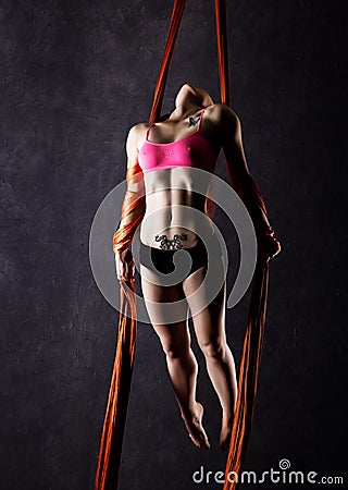 Beautiful dancer on aerial silk, graceful contortion, acrobat performs a trick on a ribbons Stock Photo