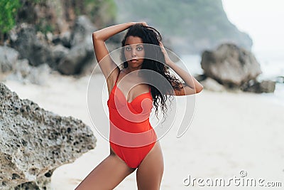 Beautiful sexy dark skinned girl in swimwear posing on white sand beach, Afro american woman resting on paradise island Stock Photo