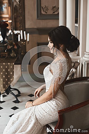 Beautiful, and fashionable brunette model girl with bright make-up and stylish hairstyle, in luxury lace dress smiling and po Stock Photo
