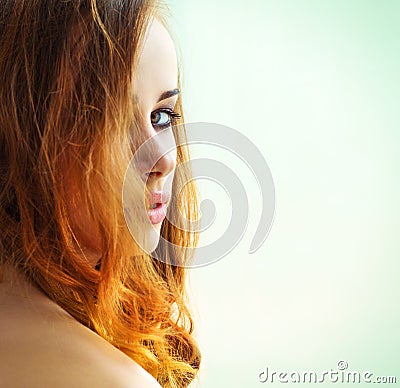 Beautiful girl with long red hair with green eyes looking out over the shoulder on a white background Stock Photo