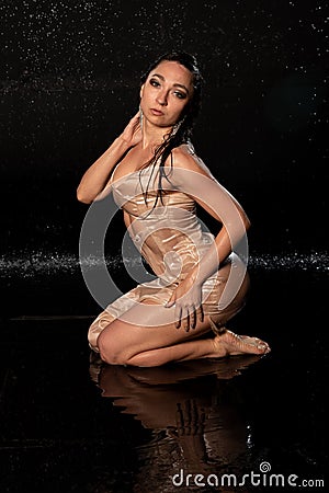 beautiful sexy model in aqua photostudio, sexy wet girl on black background, attractive girl sitting in water, aqua photography Stock Photo