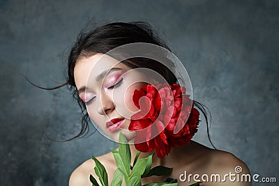 Beautiful sexy stylish young adult in elegant dress with nice bouquet of pink peonies. Studio retouched shot Stock Photo