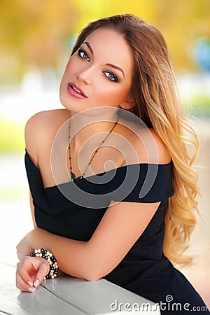 Beautiful woman with black dress and blond hair outdoor. Fashion girl Stock Photo