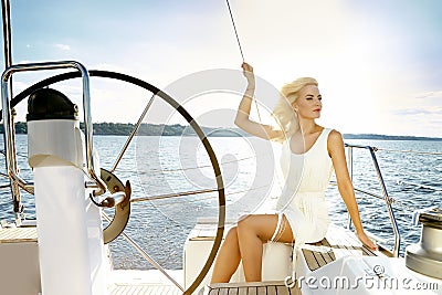 Beautiful young blonde woman, riding a boat on the water, itinerary, beautiful makeup, clothing, summer, sun, perfect body fi Stock Photo