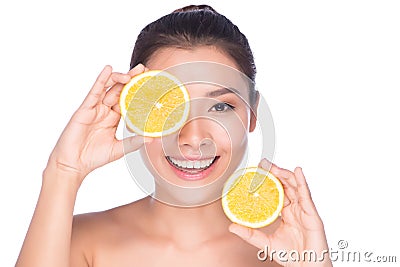 Beautiful young woman with perfect healthy skin and long brown hair day makeup bare shoulders holding orange lemon grapefrui Stock Photo