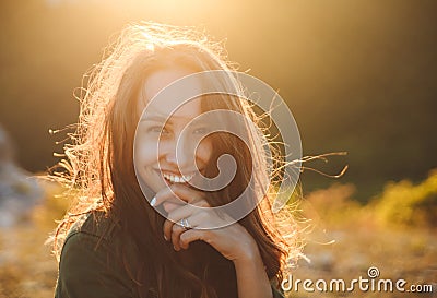 Beautiful young woman smiling on beautiful landscape in sunset time. Stock Photo