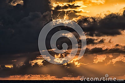 Beautiful shor of the sky with dark black clouds and the golden light of the hidden sun Stock Photo