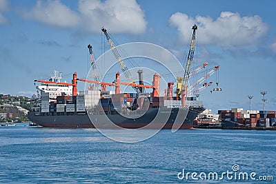 Beautiful shot of a container ship and cranes in the Tahiti port of Papeete in France Editorial Stock Photo