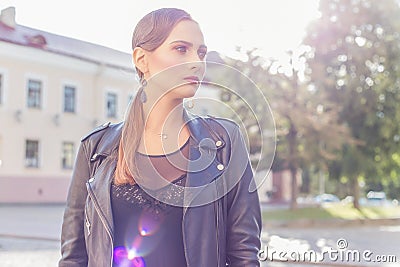 Beautiful shot of a girl with bright trendy makeup in black leather skirt in glam-rock style luchas sunlight at sunset Stock Photo