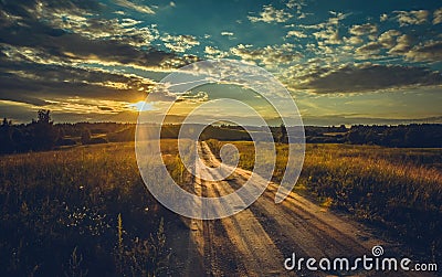 Beautiful shot of a path through a green meadow with a bright sunset sky Stock Photo