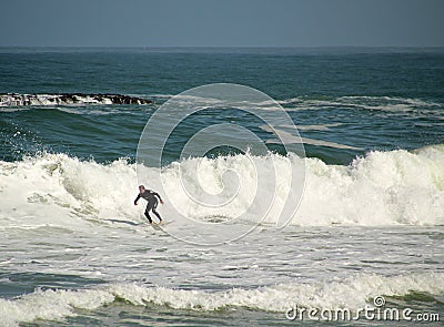 Beautiful shot of a person doing waves ride sport on board with black suit Editorial Stock Photo