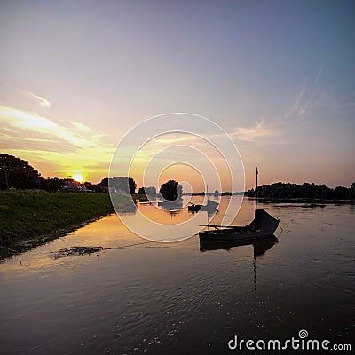 Beautiful shot of silhouettes of boats parked in a lake during the sunset Stock Photo