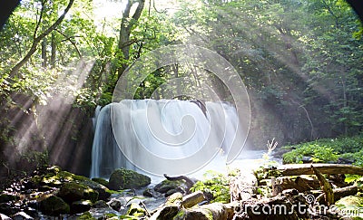 Beautiful shot of sun rays dropping on Choshi waterfall near Lake Towada in Aomori, Japan Stock Photo